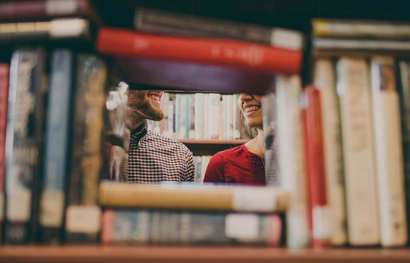 2 people standing behind a library shelf