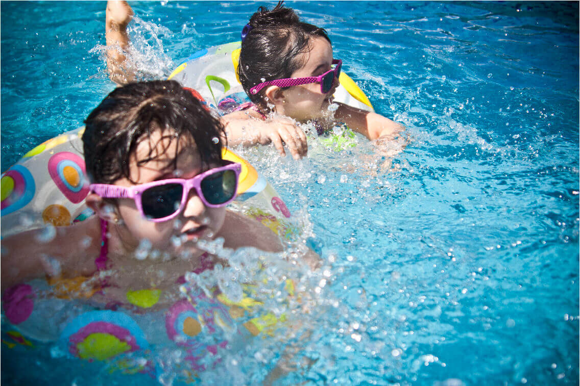 2 kids swimming in a pool