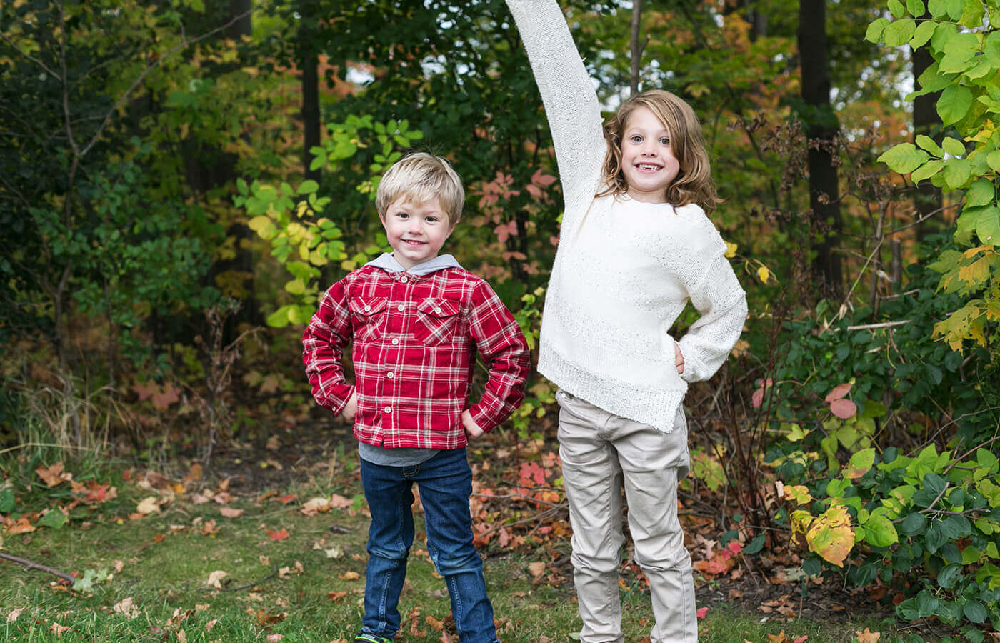 2 kids standing outside in the woods