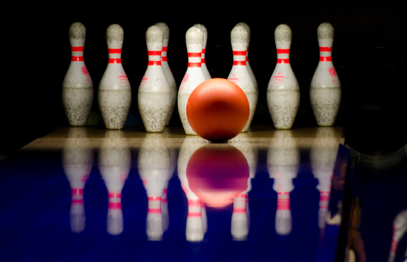 Bowling ball moments before hitting bowling pins