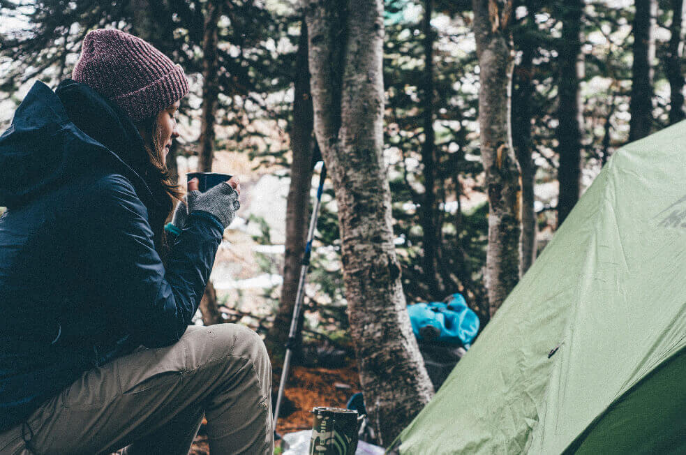 Person enjoying beverage in a campsite
