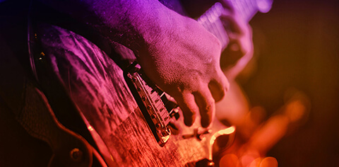Person strumming a guitar