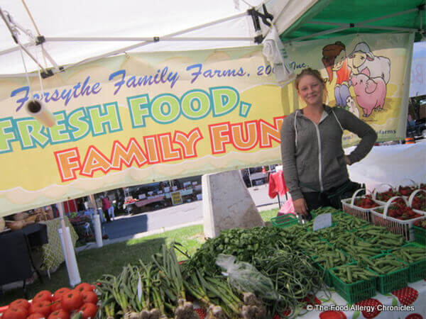 Person standing behind their stand in the farmer's market